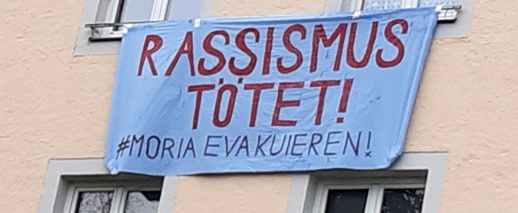 Tansparent aus einem Fenster: "Rassismus tötet! #Moria evakuieren!"