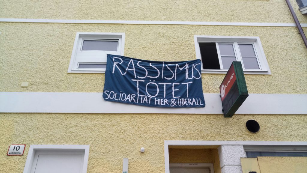 Transparent an einem Haus: "Rassismus tötet – Solidarität hier und überall"